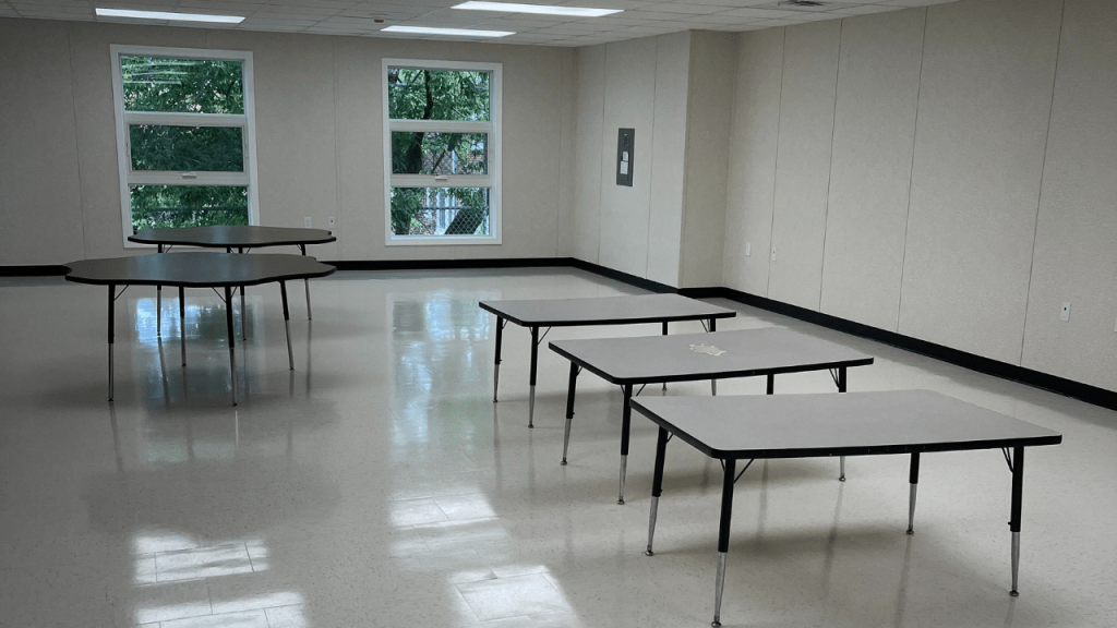 Interior view of a modular building featuring multiple tables, showcasing the flexible design of triumph modular construction for both permanent and temporary uses.