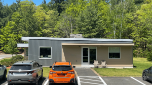 Triumph modular building with a sleek facade surrounded by greenery, showcasing modern modular construction.