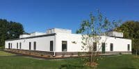 Modern permanent modular building showcasing a sleek design and efficient use of space, highlighting the benefits of modular construction in a natural setting.