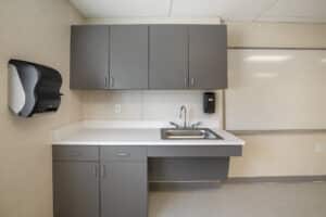 Interior shot of a sink and cabinets inside a classroom space