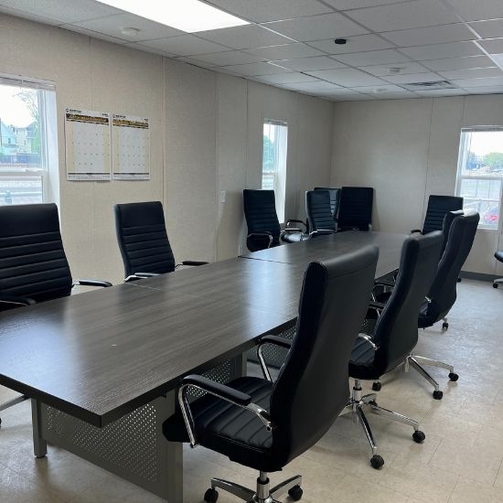 Conference room complete with Business Conference solution that includes a large conference table and eight chairs