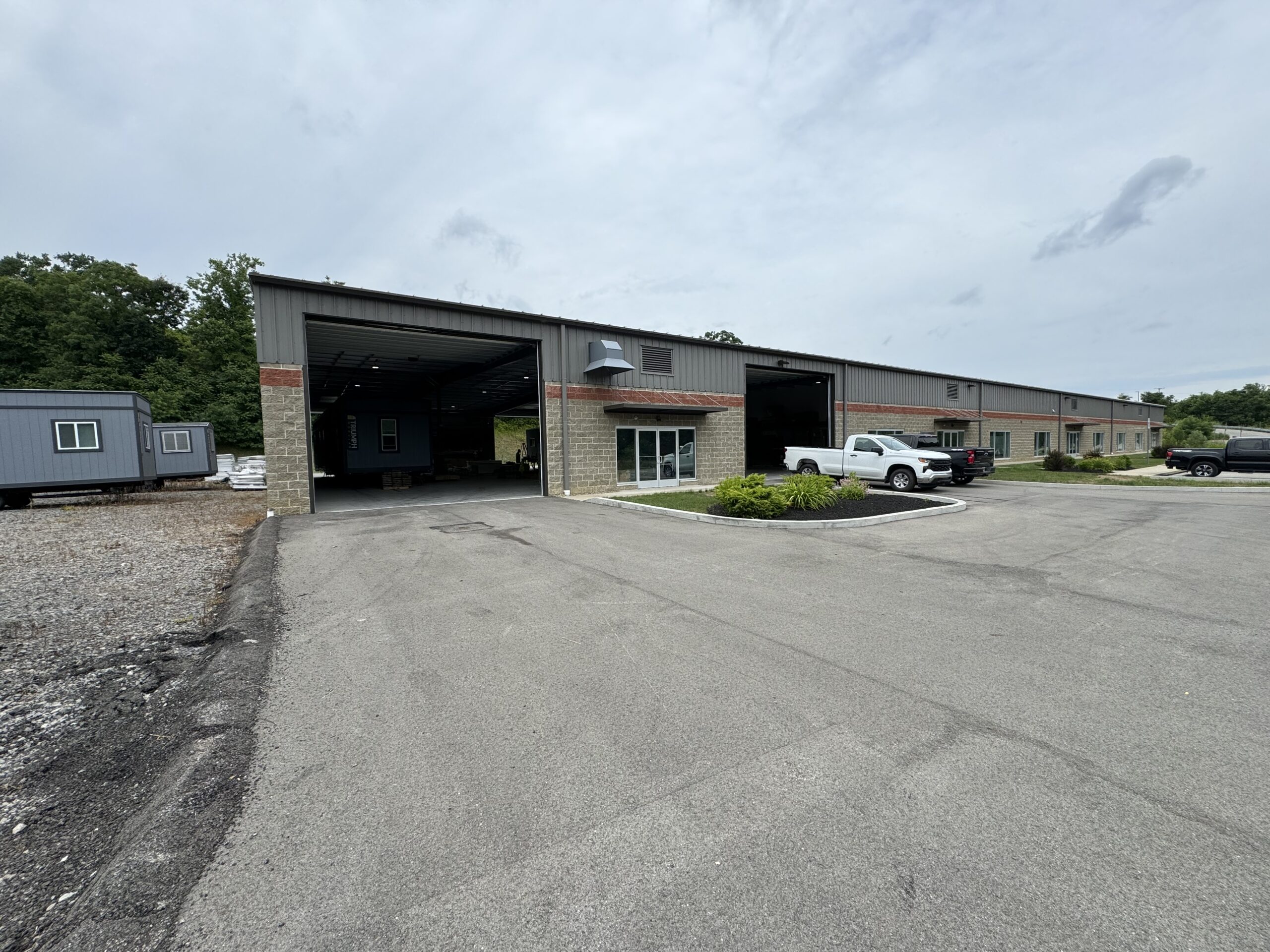 Picture of Pittsburgh branch office with Triumph Modular trailers in the yard and trucks parked in front of the building.