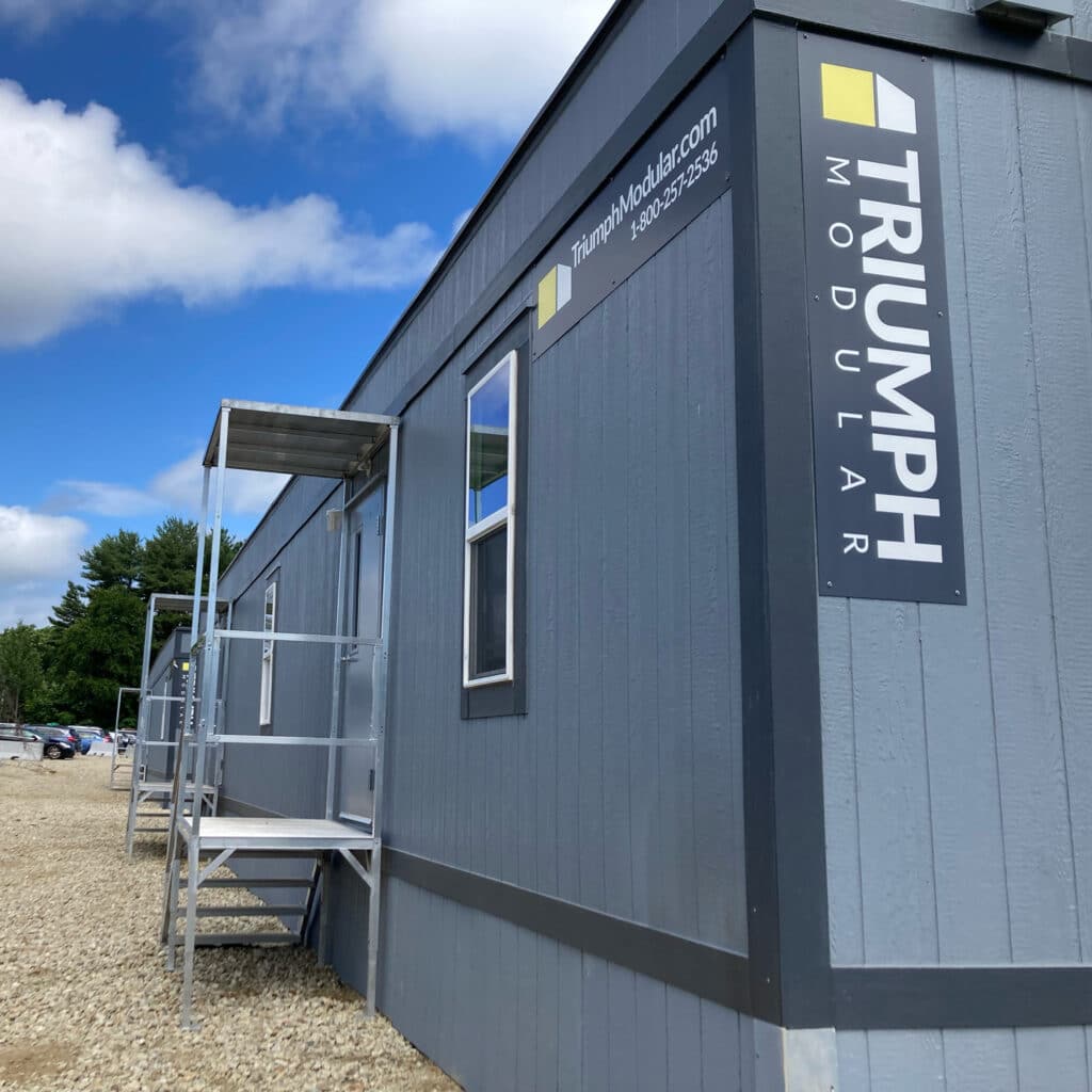 triumph construction office trailer on a jobsite with Triumph sign and dual entry with aluminum stairs