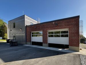 Back of fire station with two apparatus bay doors open.